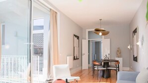 Un salon moderne comprenant un canapé, une table basse et un coin repas avec des chaises.