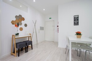 Ein moderner, minimalistischer Raum mit weißem Schreibtisch und Bank, einer sechseckigen Wanddekoration und einem Motivationsplakat.