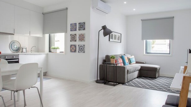 A modern, well-lit apartment with a kitchen, dining area, and living room. - Liiiving in Porto Santa Catarina Cosy Apartment (Porto)