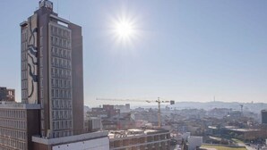 A high-rise building with a modern design, surrounded by other buildings and a construction site in the distance. - Liiiving in Porto Downtown View Apartment (Porto)