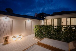 A modern outdoor patio with a wooden deck, a seating area with cushions, and a wall-mounted light fixture. - Liiiving in Porto - Soho Urban Retreat (Porto)