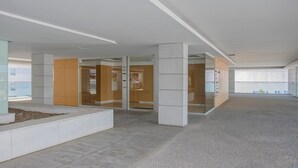A spacious lobby with a modern design, featuring a central seating area and glass doors leading to other rooms. - Liiiving in Porto Balcony Drag o View (Porto)