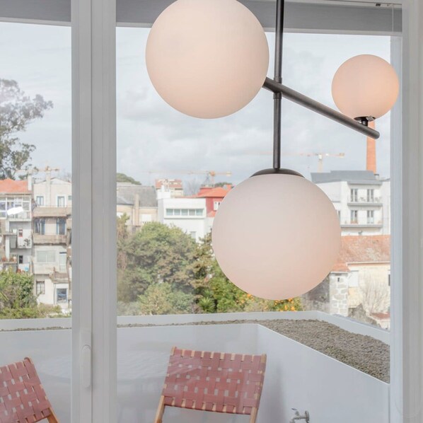 A balcony with two wicker chairs and a hanging light fixture. - Liiiving in Porto - Luxury Gallery Apartment II (Porto)