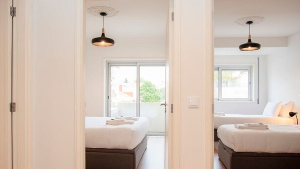 Ein modernes Hotelzimmer mit zwei Betten, einem großen Fenster und Blick nach außen.