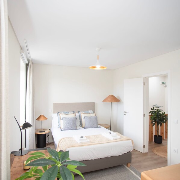 A modern bedroom with a bed, bedside lamps, a floor lamp, and a potted plant. - Liiiving in Porto - Downtown Quiet House (Porto)
