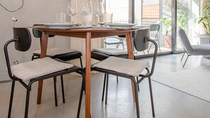 A dining area with a round table, four chairs, and a glass partition. - Liiiving in Porto - Bolh o Trendy Apartment III (Porto)