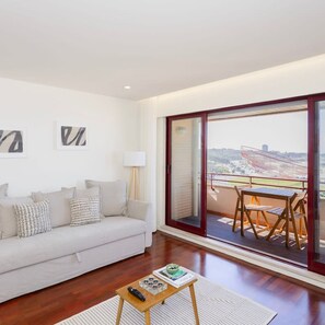 Relax in this stylish living room with a sofa, coffee table, and floor lamp, plus a balcony with outdoor seating.