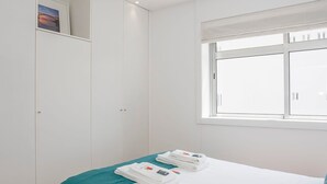 Een slaapkamer met een bed, een raam en een kledingkast.