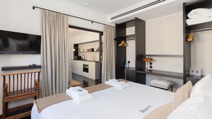 A modern hotel room with a large bed, a TV mounted on the wall, a wardrobe, and a bathroom visible through an open door. - Liiiving in Porto - Casa Duque Apartment II (Porto)