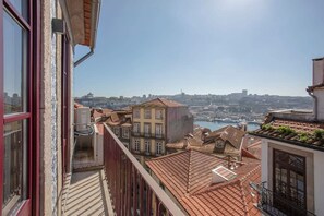 A balcony with a view of a cityscape, including buildings and a body of water. - Liiiving in Porto - Ribeira Vintage View (Porto)