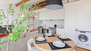 A modern kitchen with white cabinets, a built-in oven, and a washing machine. - Liiiving in Porto - Mezzanine Delight Apartment (Porto)