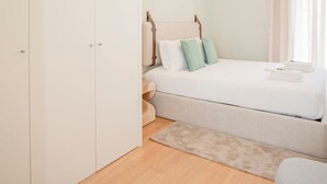 Une chambre à coucher comprenant un lit, une table de chevet, une armoire et une fenêtre avec des rideaux.