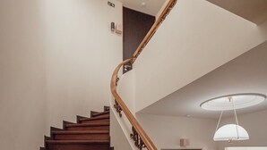 A spiral staircase with wooden handrails and carpeted steps leading to a landing. - Liiiving in Porto - Casa Duque Apartment IV (Porto)