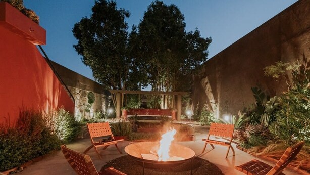 An outdoor patio with a fire pit, seating, and a view of trees. - Liiiving in Porto - Casa Duque Apartment III (Porto)