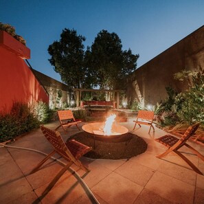 An outdoor patio with a fire pit, seating, and a view of trees. - Liiiving in Porto - Casa Duque Apartment III (Porto)