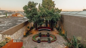 A rooftop garden with a seating area, potted plants, and a view of the cityscape. - Liiiving in Porto - Casa Duque Apartment III (Porto)