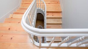 A wooden staircase with a white handrail and metal balusters. - Liiiving in Porto Historic Cl Rigos Studio - 3F (Porto)