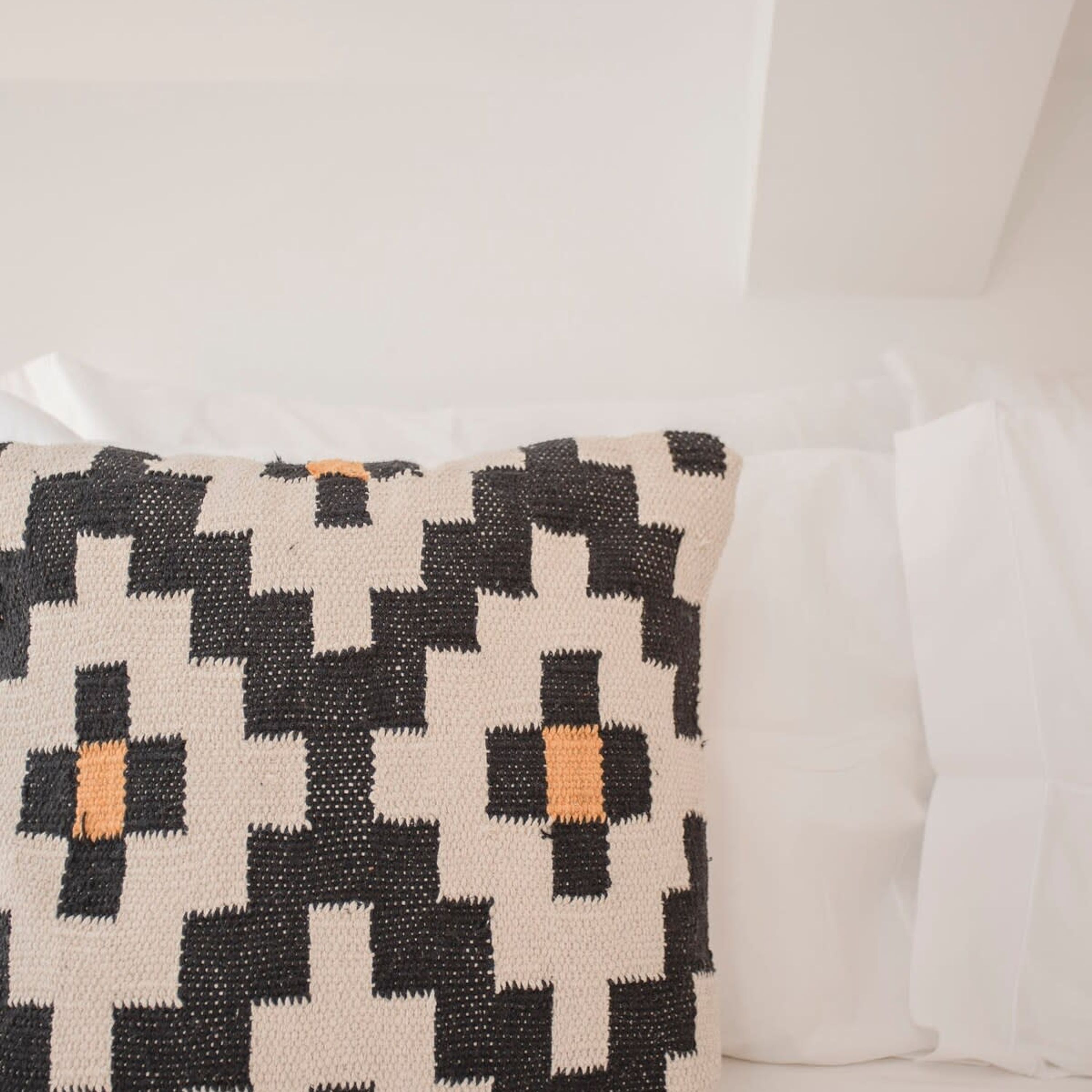 Un oreiller à motifs à carreaux noirs et blancs.