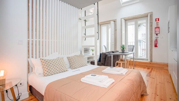 Una camera da letto moderna con un letto grande, una scrivania e un balcone.