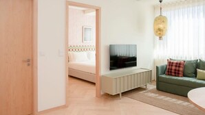 Ein modernes Wohnzimmer mit einer Couch, einem Fernseher und einem Essbereich.