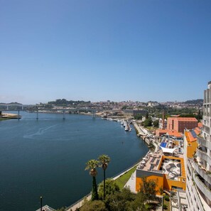A river with a bridge, a marina, and buildings with balconies overlooking the water. - Liiiving in Porto - Douro Riverside Apartment (Gondomar)