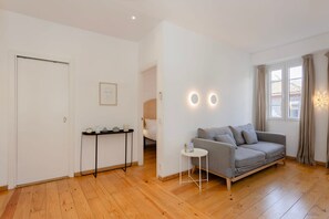 A modern living room with a grey sofa, a small round table, and a white door.