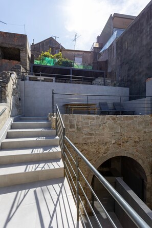 A set of concrete stairs leading up to a stone archway, with a metal railing on the left. - Liiiving In Gaia - The Wine Side XVI (Vila Nova de Gaia)