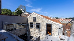 A stone building with a sign reading "The Wine Side," featuring a staircase and a view of the city. - Liiiving In Gaia - The Wine Side XVI (Vila Nova de Gaia)