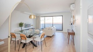 En moderne stue med et glasbord, en sofa og et fjernsyn.