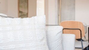 A modern living room with a sofa, a lamp, and a chair. - Liiiving in Porto - City Design Apartment Q (Porto)