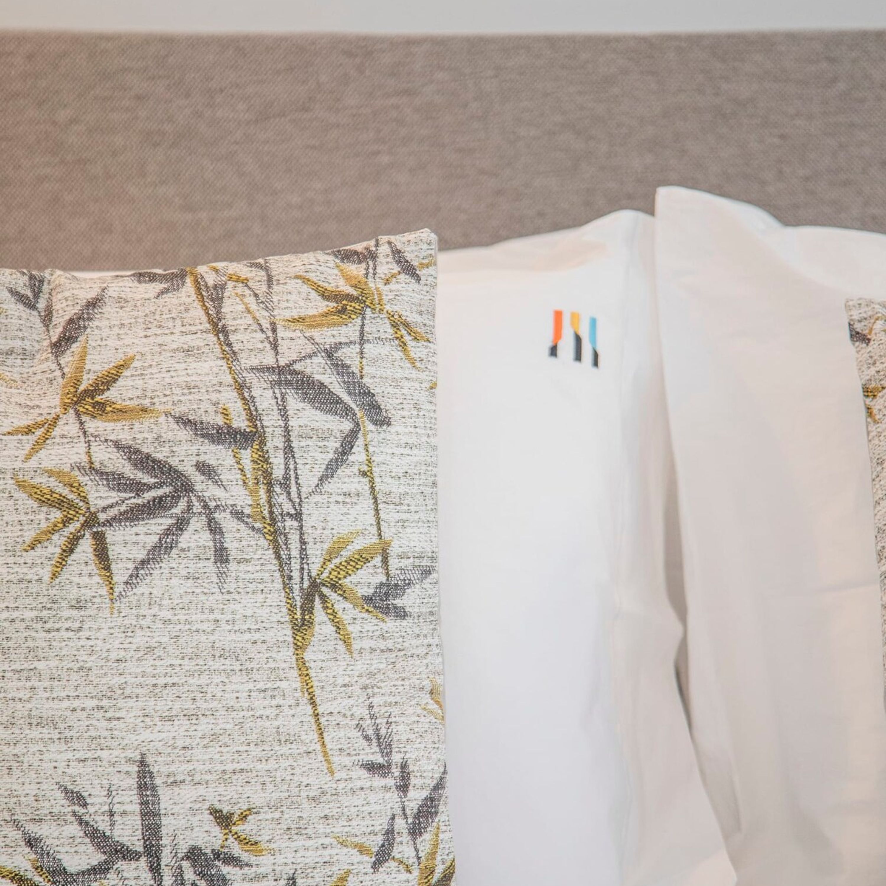 A pillow with a bamboo pattern and a plain white pillow.