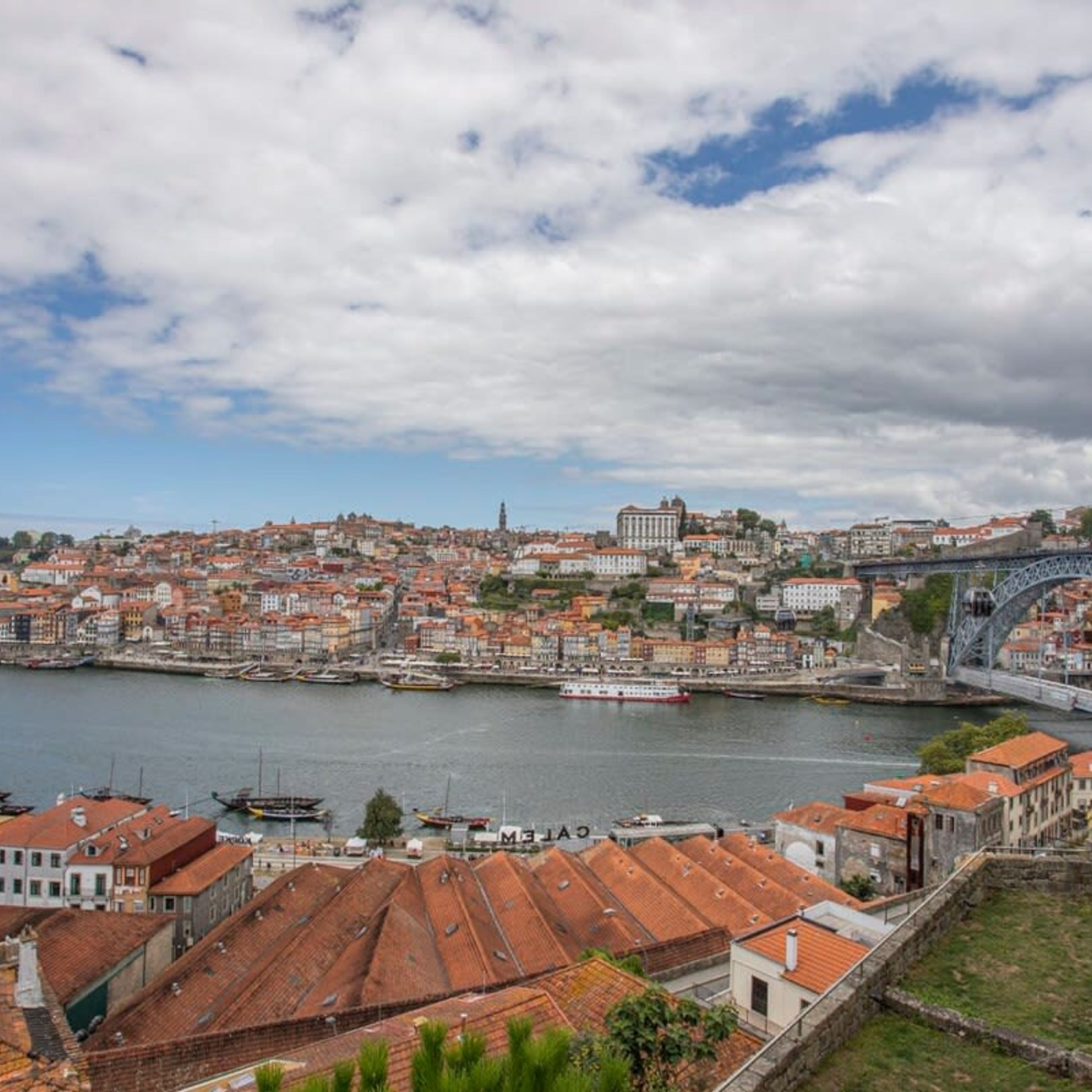 A cityscape with a river, historic buildings, and a bridge.