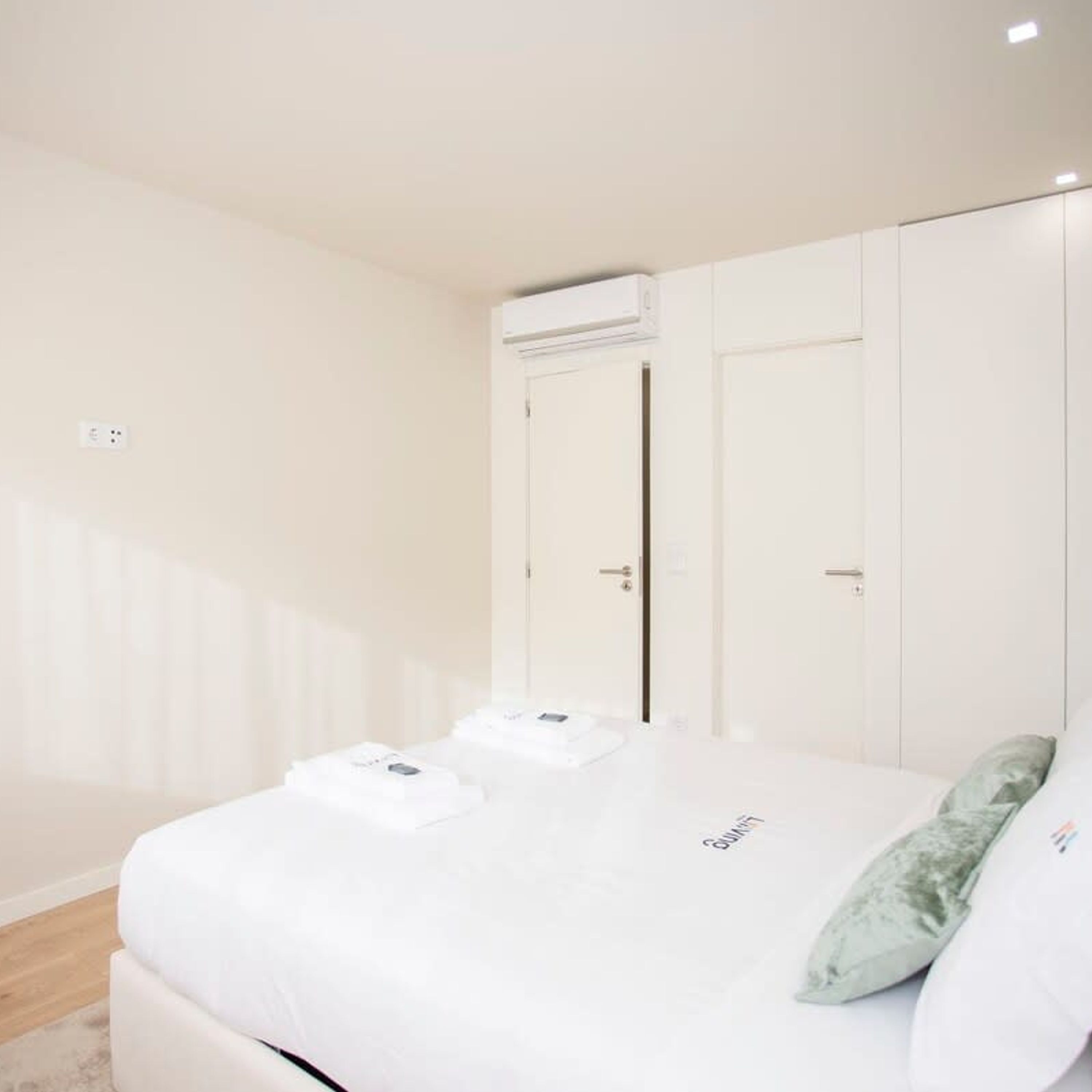Una camera da letto con un letto, un'armadio bianco e un condizionatore.