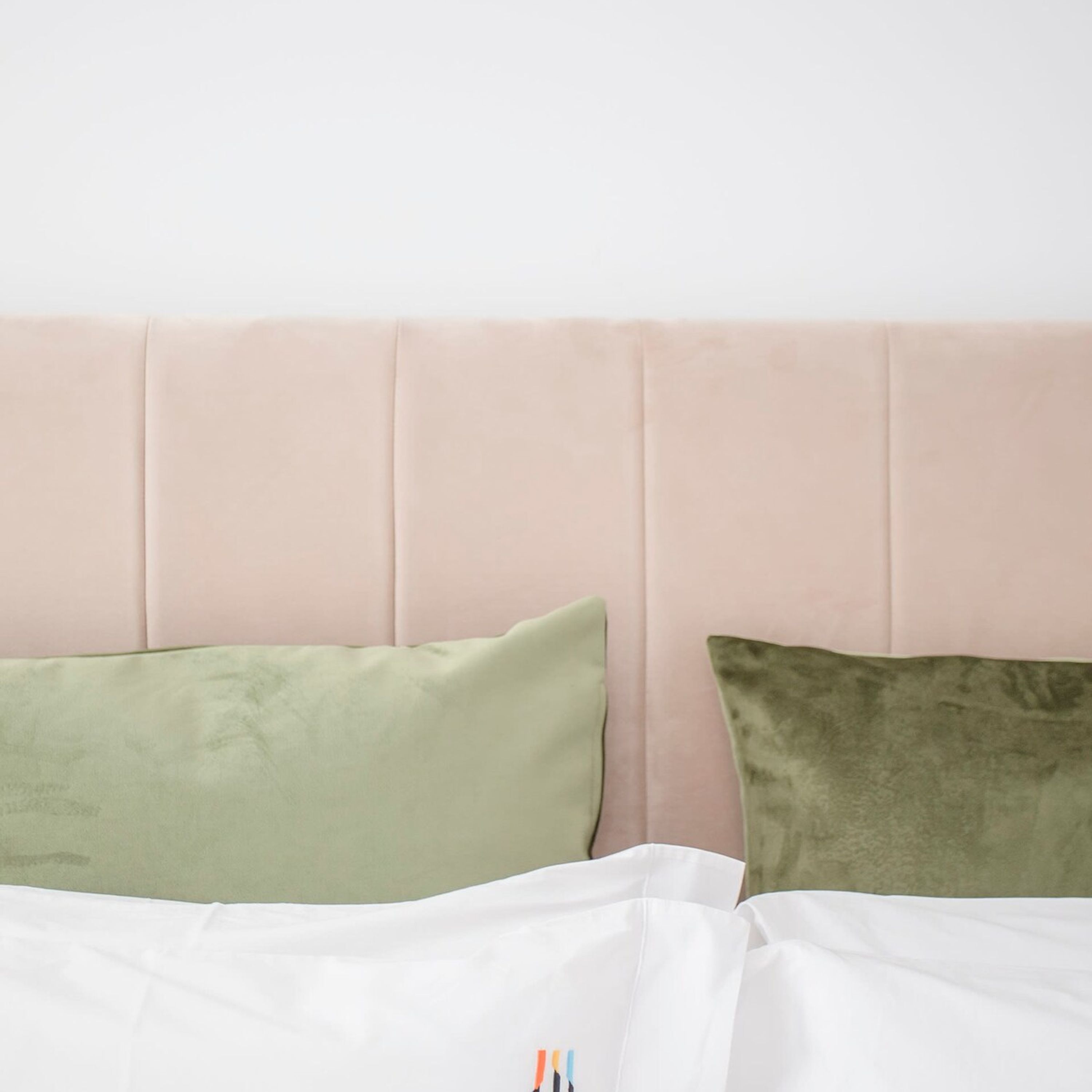 Uma cama com cabeceira e duas almofadas.