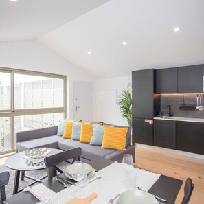 Un appartement moderne comprenant un coin repas, une cuisine et un salon.