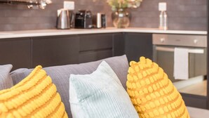A modern kitchen with dark cabinetry, a microwave, and a countertop with various appliances. - NAX Apartment G by Liiiving (Porto)