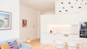 A modern apartment with a living area, a dining table, and a kitchen. - Liiiving in Porto - Haven Pool Apartment (Porto)