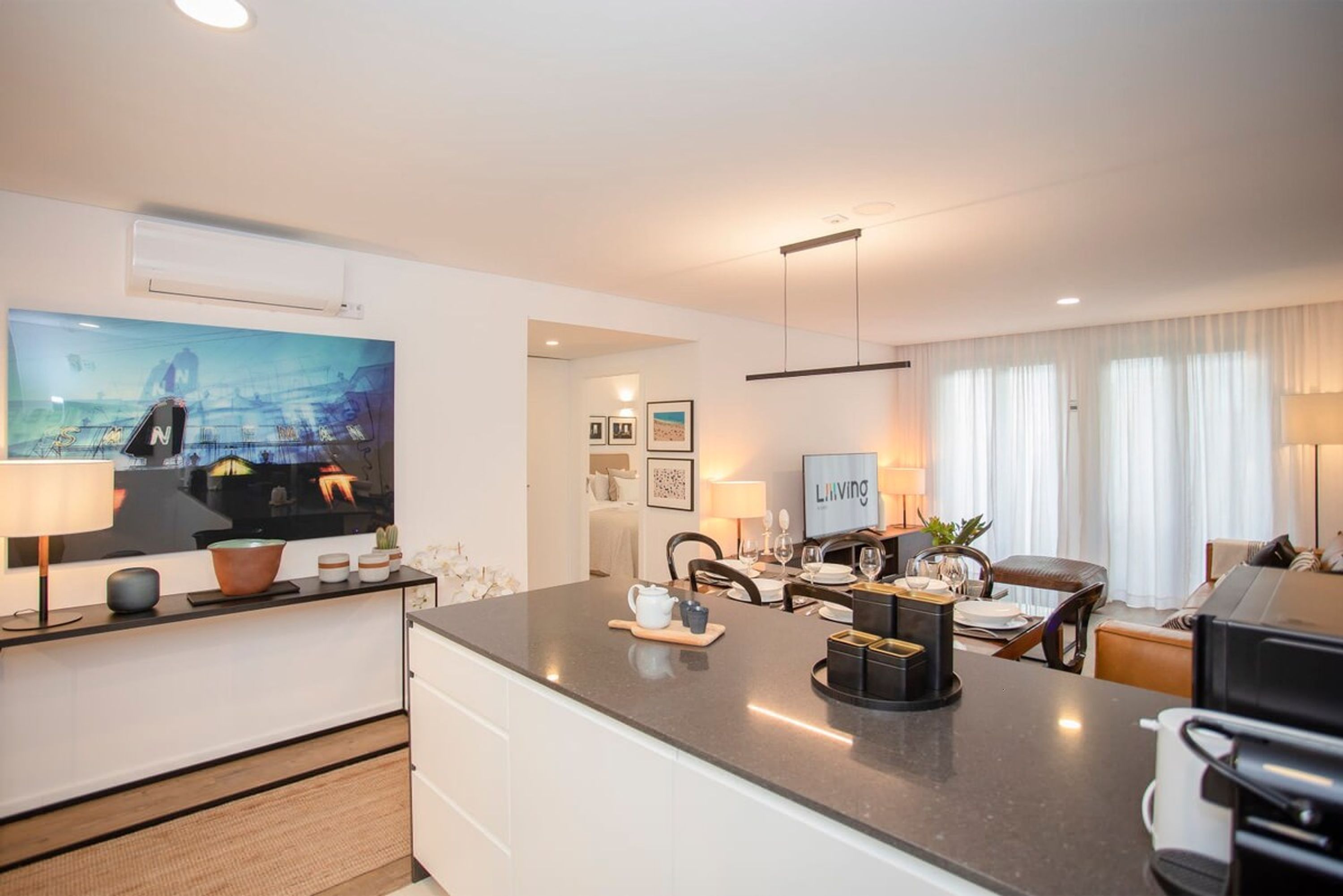 Una habitación de hotel moderna con cocina, una mesa de comedor y zona de estar.