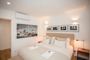 A neatly arranged bedroom with a bed, bedside tables, and wall-mounted artwork. - Liiiving in Gaia - Cooper Residence Apartment II (Vila Nova de Gaia)