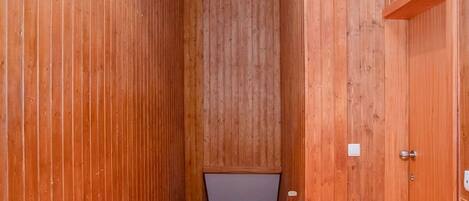 A narrow wooden hallway with a sloped ceiling and a door on the right.