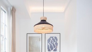 A dining area with a table and chairs, a hanging light fixture, and two framed artworks on the wall. - Liiiving in Gaia - Casa da Vinha Apartment V (Vila Nova de Gaia)