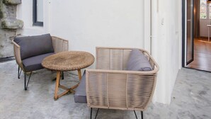 A modern outdoor seating area with wicker furniture and a concrete floor. - Liiiving in Gaia - Casa da Vinha Apartment V (Vila Nova de Gaia)