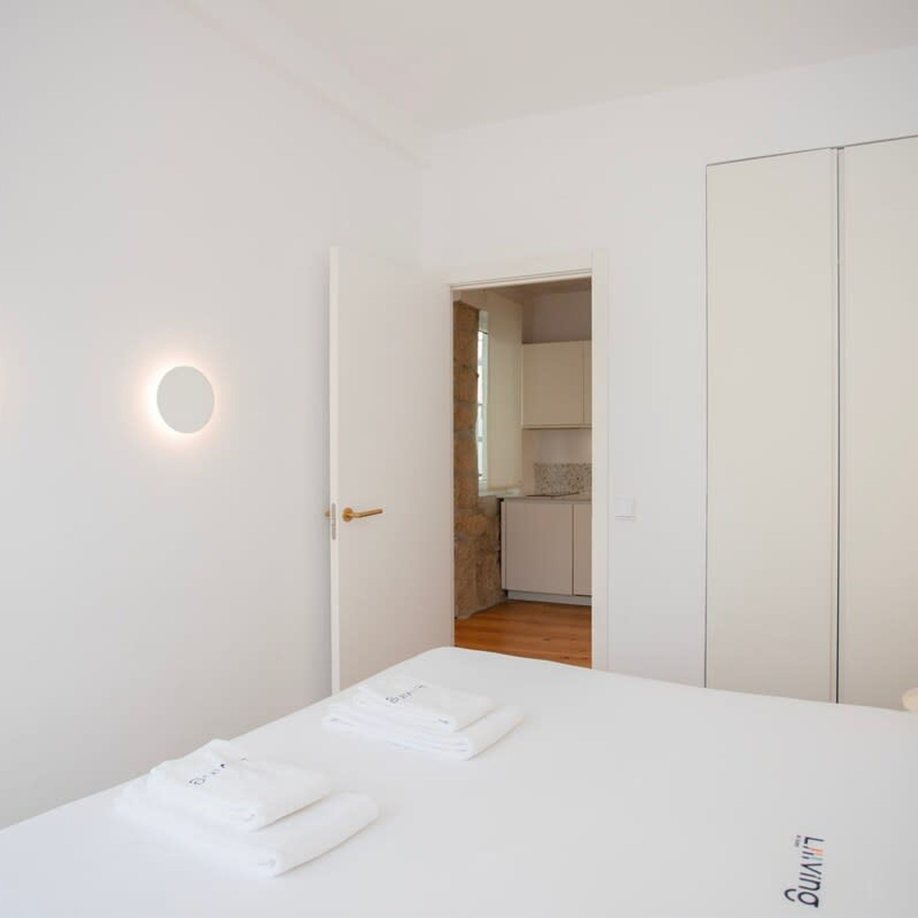 Ein Schlafzimmer mit Bett, Kleiderschrank und angrenzendem Badezimmer.