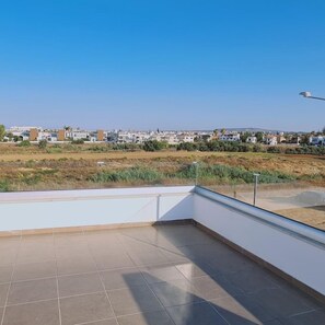 Un balcón amplio con vista despejada a una zona residencial.