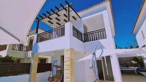 A two-story building with a balcony, a pergola, and a pool area. - 47 PEY - Peyia Kamelia Villa (Pegeia)