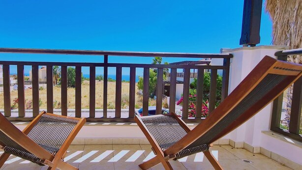 A balcony with two wooden lounge chairs and a view of the sea. - 47 PEY - Peyia Kamelia Villa (Pegeia)