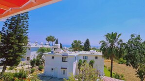 A residential area with white buildings, some with solar panels, surrounded by greenery and palm trees. - 42 PRO -stay Symphony Apartment (Paralimni)