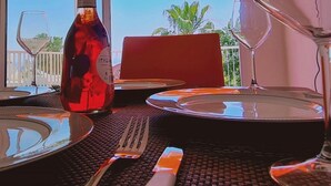 A dining table set with plates, cutlery, and a wine bottle. - 42 PRO -stay Symphony Apartment (Paralimni)