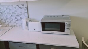 A kitchen with a microwave, toaster, and a white sink. - 14 AN - 114 Nissi Twins Apartment (Ayia Napa)