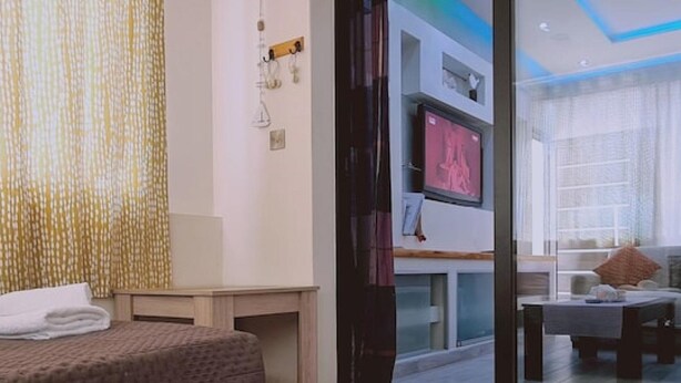 Ett modernt sovrum med en stor säng, ett skrivbord och en tv.